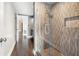 Modern shower with glass door, stone flooring, neutral tiling, and a built-in shelf at 3435 Kingsboro Ne Rd # 603, Atlanta, GA 30326