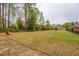 Expansive backyard has a gentle slope and is surrounded by mature trees at 9117 Dearing St, Covington, GA 30014