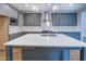 Bright kitchen with gray cabinets, white backsplash, stainless appliances, and center island with sink at 9117 Dearing St, Covington, GA 30014