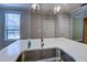 Close-up shot of a kitchen island featuring a stainless steel sink, white countertop, and modern faucet at 9117 Dearing St, Covington, GA 30014