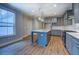 Modern kitchen features gray cabinets, stainless steel appliances, and a center island with a sink at 9117 Dearing St, Covington, GA 30014