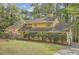 Charming two-story yellow home with mature trees and an inviting landscaped yard at 103 Nob Hl, Peachtree City, GA 30269