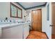 Functional laundry room with tile flooring, washer, dryer, and wooden door at 103 Nob Hl, Peachtree City, GA 30269