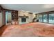Cozy living room featuring a stone fireplace, carpeted floor, and large bright windows at 103 Nob Hl, Peachtree City, GA 30269