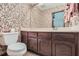 Powder room with wood vanity, tile floor and floral wallpaper at 103 Nob Hl, Peachtree City, GA 30269
