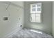 Bright laundry room with white walls, modern gray-toned floors, and a window for natural light at 158 Hemphill School Rd, Atlanta, GA 30331