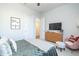 A cozy bedroom featuring a plush bed, a wooden dresser with a TV, and a comfortable chair with throw pillows at 158 Village Green Ave, Woodstock, GA 30189
