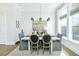 Bright dining area with modern chandelier, gray chairs, and natural light through large windows at 158 Village Green Ave, Woodstock, GA 30189