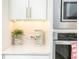Modern kitchen with white cabinets, stainless steel appliances, and quartz countertops at 158 Village Green Ave, Woodstock, GA 30189