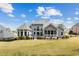 Backyard view of a home with a well-manicured lawn, screened-in porch, and large windows at 214 Cedar Woods Way, Canton, GA 30114
