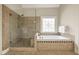 Bright bathroom featuring a glass shower, soaking tub with tile detailing, and a decorative window at 214 Cedar Woods Way, Canton, GA 30114