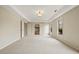 Well-lit bedroom with plush carpeting, tray ceiling, and a doorway to another room at 214 Cedar Woods Way, Canton, GA 30114