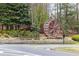 The community entrance features a brick water wheel and 'BRIDGE MILL' sign surrounded by trees and landscaping at 214 Cedar Woods Way, Canton, GA 30114