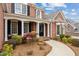 Inviting front porch with decorative columns, a cozy bench, and a beautifully landscaped walkway leading to the front door at 214 Cedar Woods Way, Canton, GA 30114