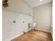 Bright laundry room with a utility sink and wooden floors at 214 Cedar Woods Way, Canton, GA 30114