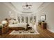 Staged main bedroom featuring tray ceiling, hardwood floors, and scenic backyard views at 214 Cedar Woods Way, Canton, GA 30114