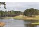 Picturesque pond view with a water feature and golf course in the backdrop, surrounded by lush greenery at 214 Cedar Woods Way, Canton, GA 30114