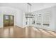 Bright dining area with hardwood floors, a modern chandelier, and a view of the front yard at 7043 Foundry Dr, Woodstock, GA 30188