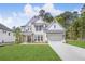 Beautiful two-story home features a manicured lawn, two-car garage, and a classic white brick facade at 7043 Foundry Dr, Woodstock, GA 30188