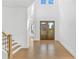 Grand foyer with hardwood floors and a soaring ceiling features a staircase and large front doors at 7043 Foundry Dr, Woodstock, GA 30188