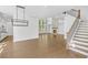 Open-concept living room with hardwood floors, modern light fixtures, fireplace and staircase at 7043 Foundry Dr, Woodstock, GA 30188