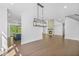 Open-concept living area with hardwood floors, modern lighting, and adjacent kitchen and fireplace at 7043 Foundry Dr, Woodstock, GA 30188