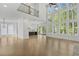 Expansive living area with hardwood floors, floor-to-ceiling windows, and an open view of the kitchen at 7043 Foundry Dr, Woodstock, GA 30188