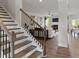 Inviting entryway with wood stairs, iron railings, hardwood floors and view into the living room at 3710 Near Star Ln, Cumming, GA 30028