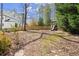 Large backyard with a playground, lush greenery, and ample space for outdoor activities at 495 Heritage Way, Atlanta, GA 30328