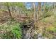 A rocky creek flows through a lush wooded area, showcasing a natural and tranquil environment at 495 Heritage Way, Atlanta, GA 30328