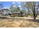 Traditional brick home with a large front yard and mature trees, offering a serene setting at 495 Heritage Way, Atlanta, GA 30328