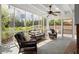 Inviting screened porch featuring wicker furniture, a ceiling fan, and views of the lush landscaping at 495 Heritage Way, Atlanta, GA 30328
