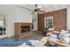 Cozy screened porch with a brick fireplace, wicker seating, and a ceiling fan for comfortable outdoor living at 495 Heritage Way, Atlanta, GA 30328