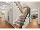A staircase featuring dark, modern banisters, natural wood steps and trim, and light walls at 495 Heritage Way, Atlanta, GA 30328