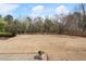 Expansive backyard with mature trees, playset, and trampoline, perfect for outdoor activities and entertaining at 923 Port West Dr, Auburn, GA 30011