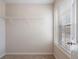 Small carpeted closet with shelves and natural light from a window at 923 Port West Dr, Auburn, GA 30011