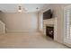Carpeted living room featuring a fireplace with a white mantle, built in TV and door to patio at 923 Port West Dr, Auburn, GA 30011