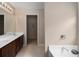 Main bathroom featuring double sinks, white countertops, and a view into the walk-in closet at 923 Port West Dr, Auburn, GA 30011