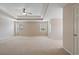 Large main bedroom featuring tray ceiling, ceiling fan, neutral carpet, and ample natural light at 923 Port West Dr, Auburn, GA 30011