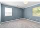 Well-lit bedroom boasts plush carpeting, two windows, and light blue walls, radiating a refreshing vibe at 1531 Stone Gate Se Ln, Atlanta, GA 30317
