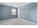 Bedroom featuring a neutral carpet, window, door, and light blue painted walls, creating a calm ambiance at 1531 Stone Gate Se Ln, Atlanta, GA 30317
