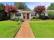 Charming home featuring a well-manicured lawn and vibrant red-flowered trees framing the entrance at 1531 Stone Gate Se Ln, Atlanta, GA 30317