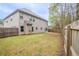 Backyard featuring lawn, home exterior, and wooden fence along perimeter at 3443 Woodshade Dr, Loganville, GA 30052