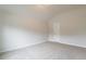 Bright, carpeted bedroom featuring neutral walls, a vaulted ceiling, and a white door at 3443 Woodshade Dr, Loganville, GA 30052