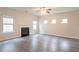 Bright living room features a fireplace, three windows, and hardwood floors at 3443 Woodshade Dr, Loganville, GA 30052