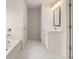 Elegant bathroom with marble-look tile floors, white vanity, a bathtub, and modern lighting at 3720 Near Star Ln, Cumming, GA 30028