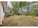 A spacious yard with mature trees and a back deck with stairs offers a serene outdoor setting at 419 Fincher Rd, Covington, GA 30016