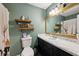 Updated bathroom with marble countertop, black cabinetry, and decorative shelving at 419 Fincher Rd, Covington, GA 30016
