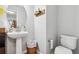 Charming half bathroom with pedestal sink and a decorative mirror at 230 Silver Fox Trl, Dallas, GA 30157