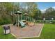 Community playground with green play structure, slide, mulch, and surrounding lush trees at 230 Silver Fox Trl, Dallas, GA 30157